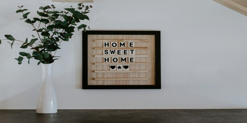 Home Sweet Home sign and greenery on a shelf