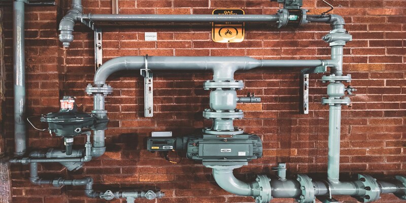 Pipework and valves on a brick wall