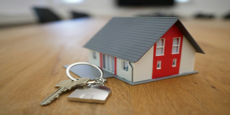 Model home and house keys on a wooden table
